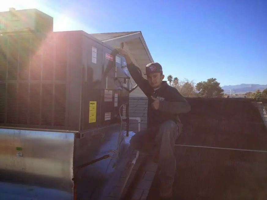 HVAC technician performing Air Duct Repair on a rooftop unit in Redwood City